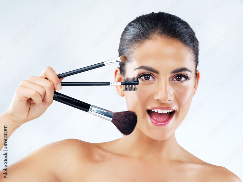 Portrait, girl and makeup with brush in studio for cosmetic application, beauty transformation and salon glow. Smile, woman facial shine with product tools for aesthetic makeover on blue background Portrait, girl and makeup with brush in studio for cosmetic application, beauty transformation and salon glow. Smile, woman facial shine with product tools for aesthetic makeover on blue background