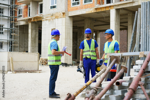 Engineer coworker in protective workwear discussing while working together at construction site