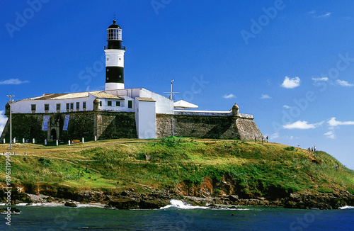 The Barra Lighthouse, Farol da Barra, in the entrance of the Bay of All Saints. It was built into of the Santo Antônio da Barra Fort, its tapered tower has a Fresnel lens dating to 1890, Salvador, BA, photo