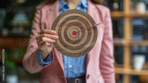 Woman Holding Wooden Target With Arrow In Bullseye