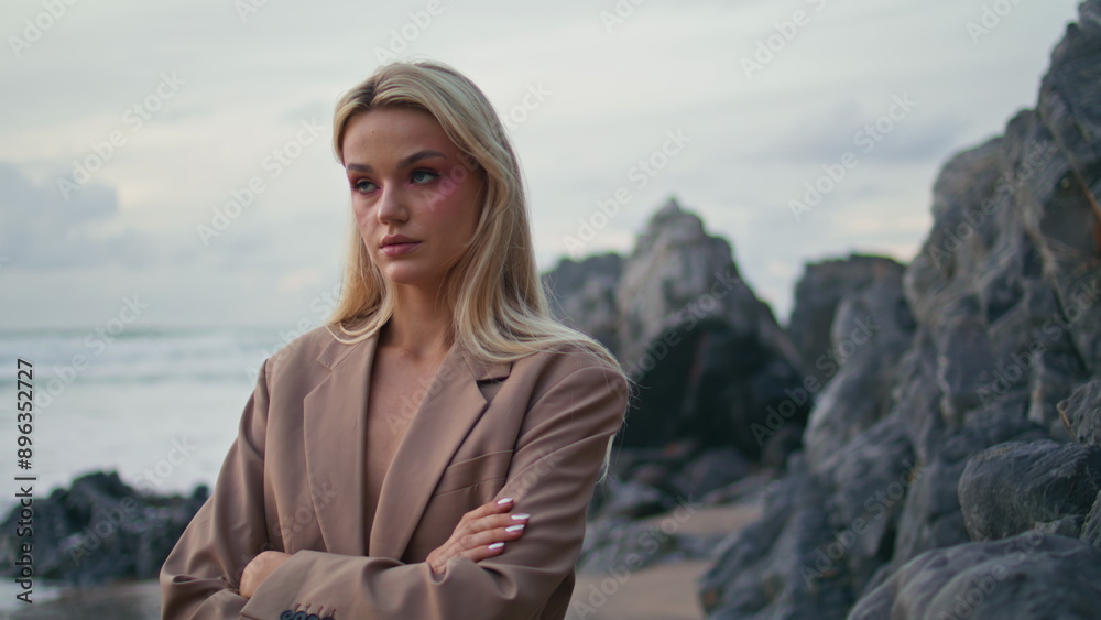 Blonde girl posing coast in gloomy evening portrait. Contemplative model turning Blonde girl posing coast in gloomy evening portrait. Contemplative model turning