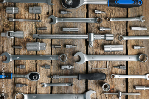 Different auto mechanic's tools on wooden table, flat lay