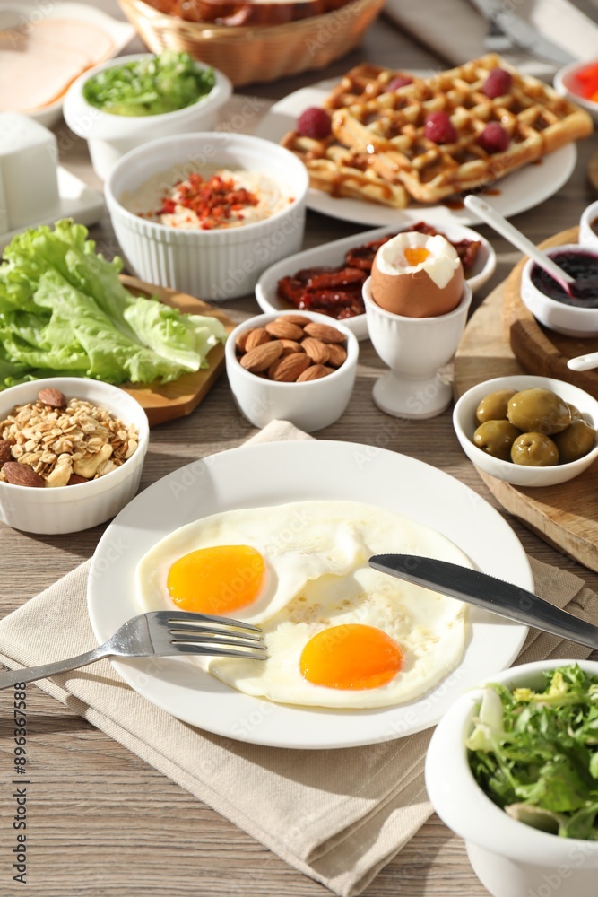 Different meals served for breakfast on wooden table Different meals served for breakfast on wooden table