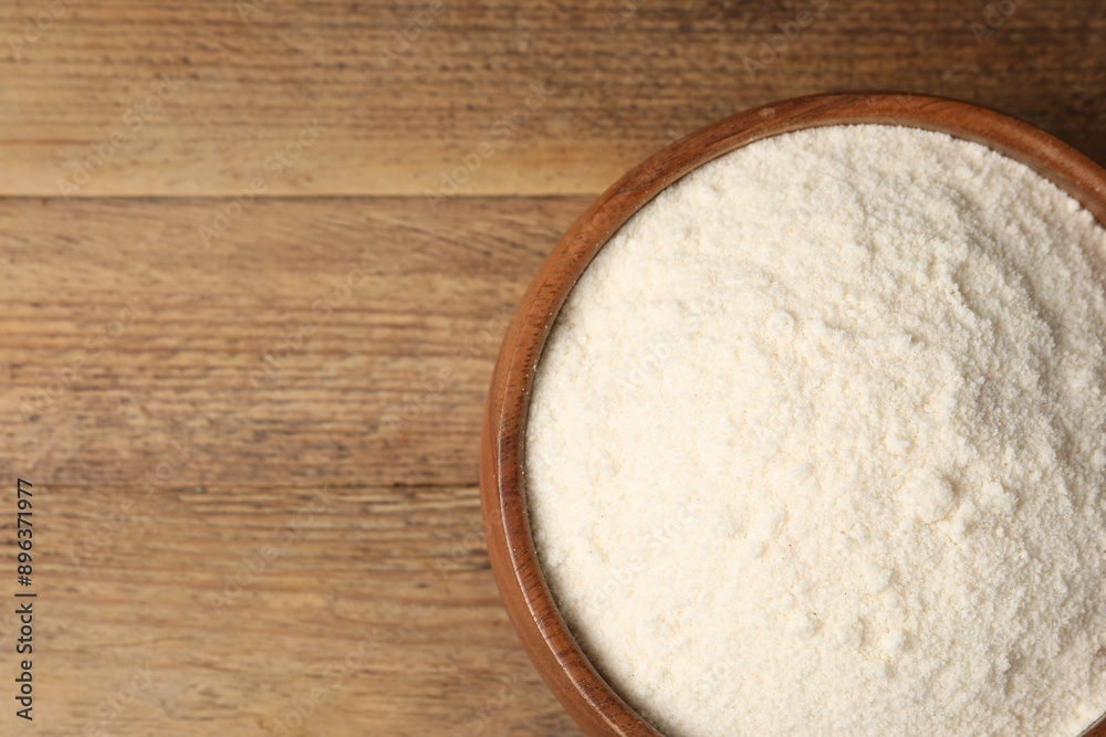 Coconut flour in bowl on wooden table, top view. Space for text Coconut flour in bowl on wooden table, top view. Space for text