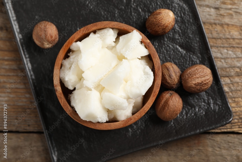 Natural shea butter and nuts on wooden table, top view Natural shea butter and nuts on wooden table, top view