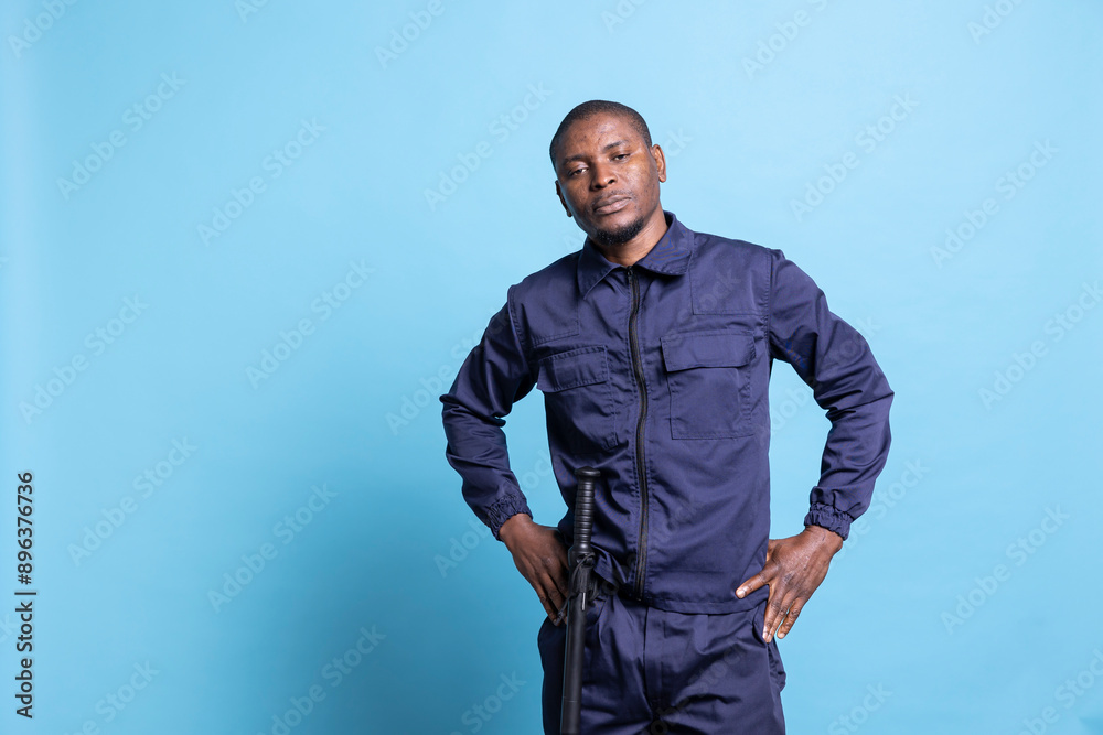 Security guard showing his authority by posing with hand on his hips ...