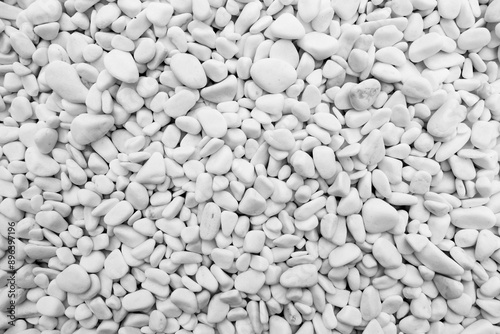 Close-up for oval pebbles of white gravel stones. White gravel as a decorative and architectural ingredient. Shot taken with natural lighting.