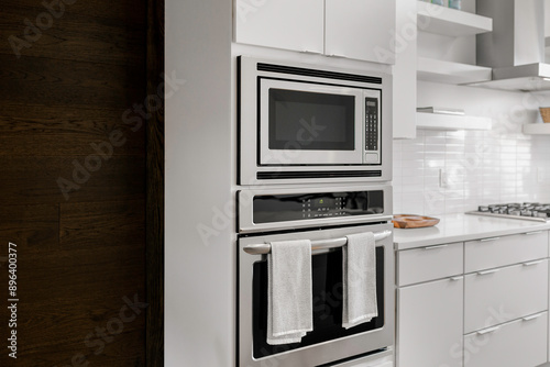 Modern Kitchen With Built-In Stainless Steel Microwave And Oven, White Cabinets photo