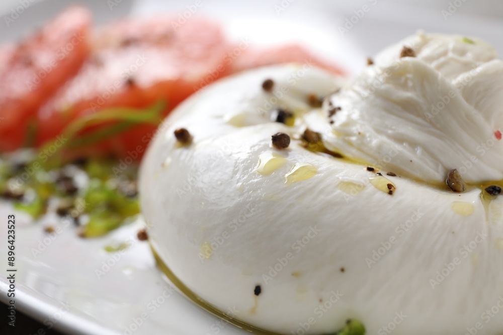 Delicious burrata cheese and spices on plate, closeup Delicious burrata cheese and spices on plate, closeup