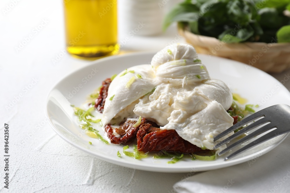 Delicious burrata cheese and sun-dried tomatoes served on white table, closeup Delicious burrata cheese and sun-dried tomatoes served on white table, closeup