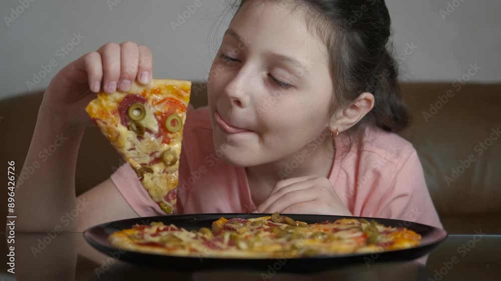 Alone child sitting in kitchen with pizza. A view of joyful little girl sitting by the kitchen table and enjoy the view of tasty homemade pizza. Alone child sitting in kitchen with pizza. A view of joyful little girl sitting by the kitchen table and enjoy the view of tasty homemade pizza.