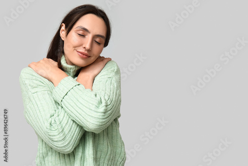 Young woman hugging herself...