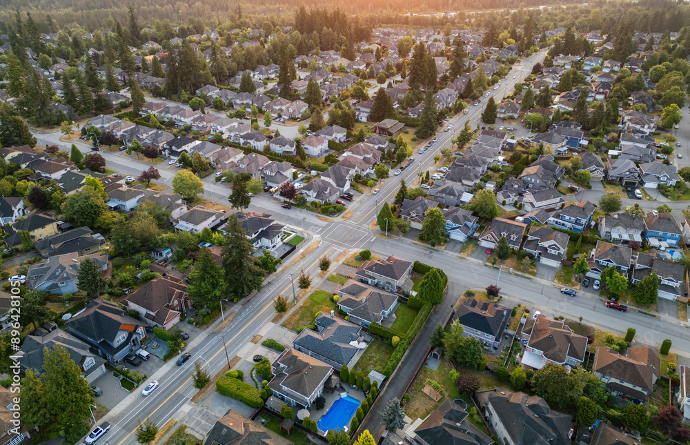 Naklejka premium Aerial View of Residential Homes in Suburban City. Sunny Summer Sunrise.