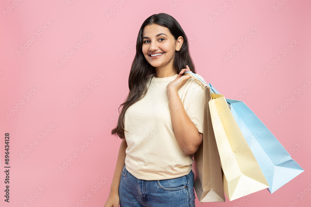 Happy woman wearing casual T-shirt and jeans holding shopping bags enjoying her purchases Happy woman wearing casual T-shirt and jeans holding shopping bags enjoying her purchases