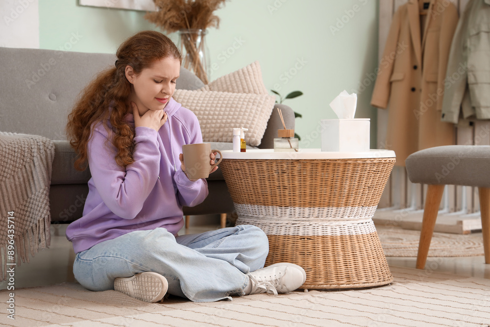 Sick young woman with sore throat, cup of tea and medicine at home Sick young woman with sore throat, cup of tea and medicine at home