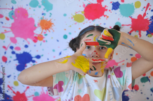 menina com rosto colorido divertimento com tintas coloridas recreação escolar criativa  photo