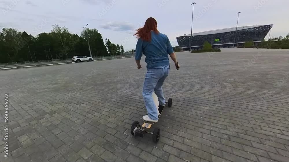 Caucasian woman rides an electric longboard with her Jack Russell Terrier dog. Caucasian woman rides an electric longboard with her Jack Russell Terrier dog.