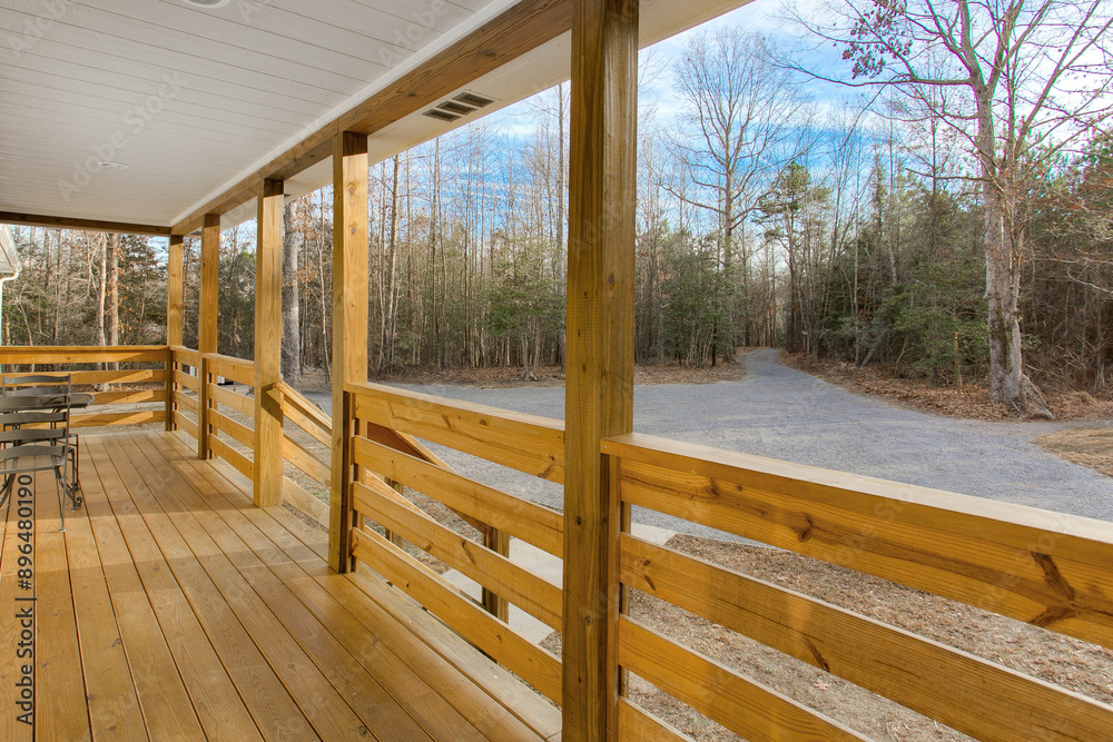 Fototapeta premium Wide Wooden Porch With Natural Railing Set Amidst A Serene Forest Background in Winter
