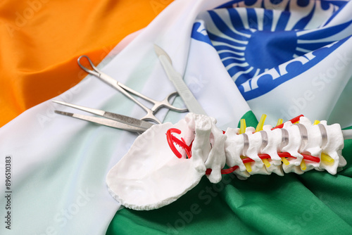 Surgical tools and spine model on flag of India, closeup. National Doctor's Day celebration photo