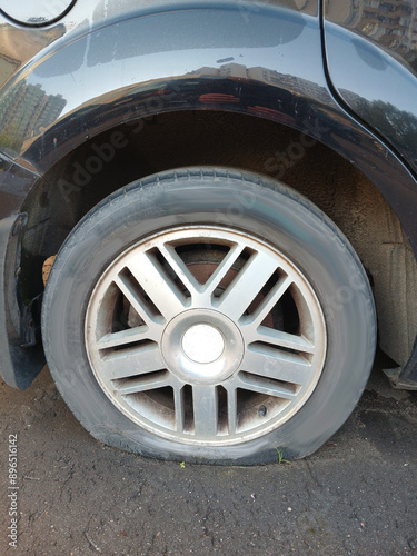 A deflated car wheel. Close. Vertical snapshot