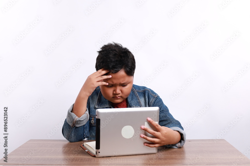 asian child headache on studying online class or kid boy student thinking or stressed learning on computer tablet by video call or person learn from home school and hand raising or holding to head asian child headache on studying online class or kid boy student thinking or stressed learning on computer tablet by video call or person learn from home school and hand raising or holding to head