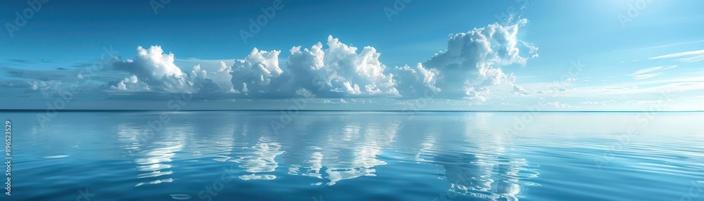 Obraz premium A beautiful blue ocean with a few clouds in the sky