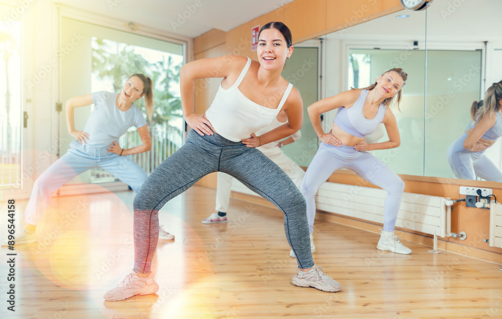Obraz premium Ordinary active females exercising dance moves in a modern dance studio