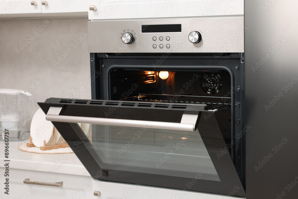 Open electric oven with towel in kitchen. Cooking appliance Open electric oven with towel in kitchen. Cooking appliance