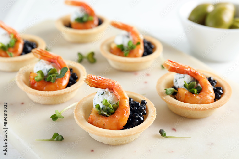 Delicious canapes with shrimps and black caviar on table, closeup Delicious canapes with shrimps and black caviar on table, closeup