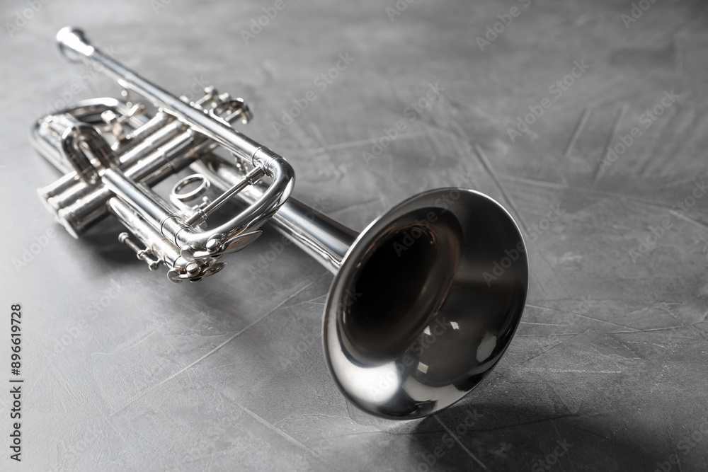 Obraz premium Closeup view of shiny trumpet on grey textured table. Wind musical instrument