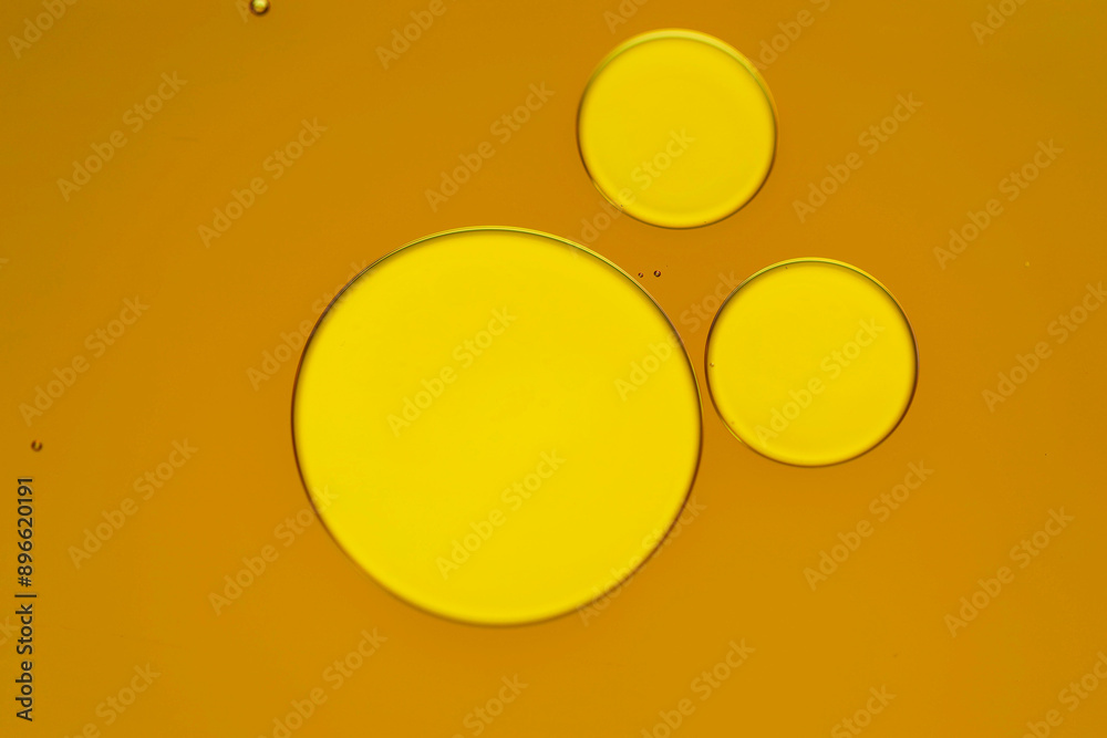Sample of cosmetic oil on dark yellow background, macro view Sample of cosmetic oil on dark yellow background, macro view