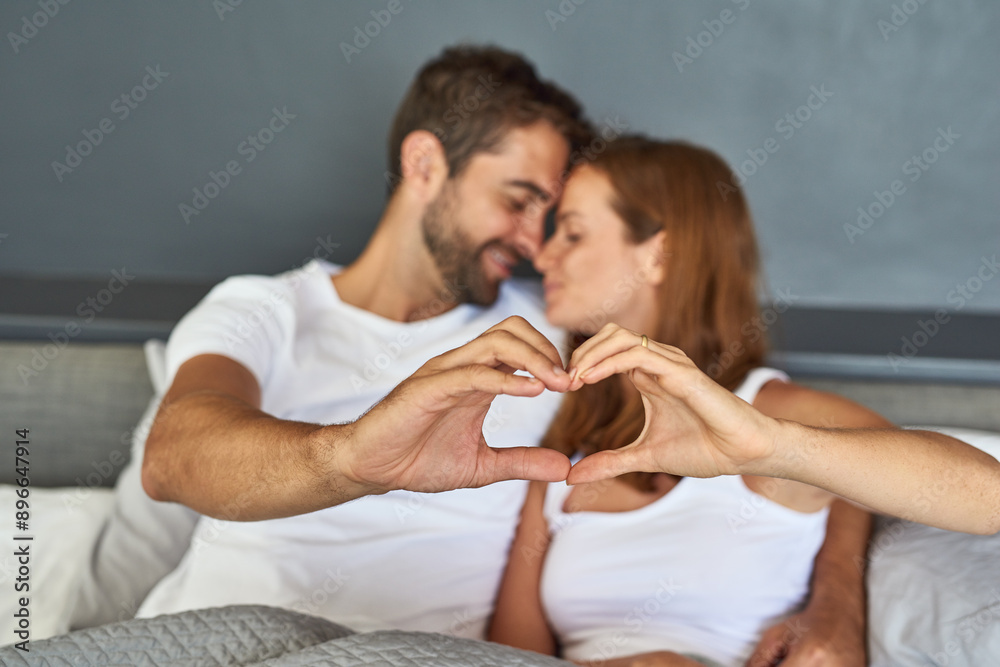 Relax, couple and hands with heart in bedroom for healthy connection, commitment and trust in marriage. Woman, man and smile with love emoji at home for romance, appreciation and gratitude together