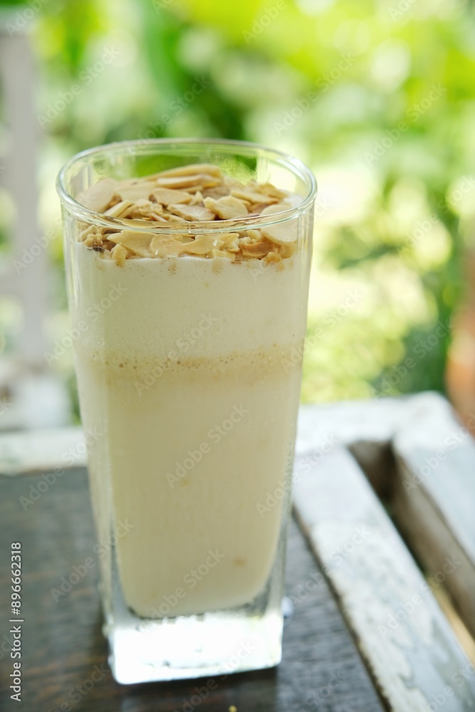 Refreshing creamy vanilla smoothie topped with almond flakes, ideal for food blogs, health magazines, and beverage advertisements. Highlights the creamy texture and nutty garnish, Refreshing creamy vanilla smoothie topped with almond flakes, ideal for food blogs, health magazines, and beverage advertisements. Highlights the creamy texture and nutty garnish,