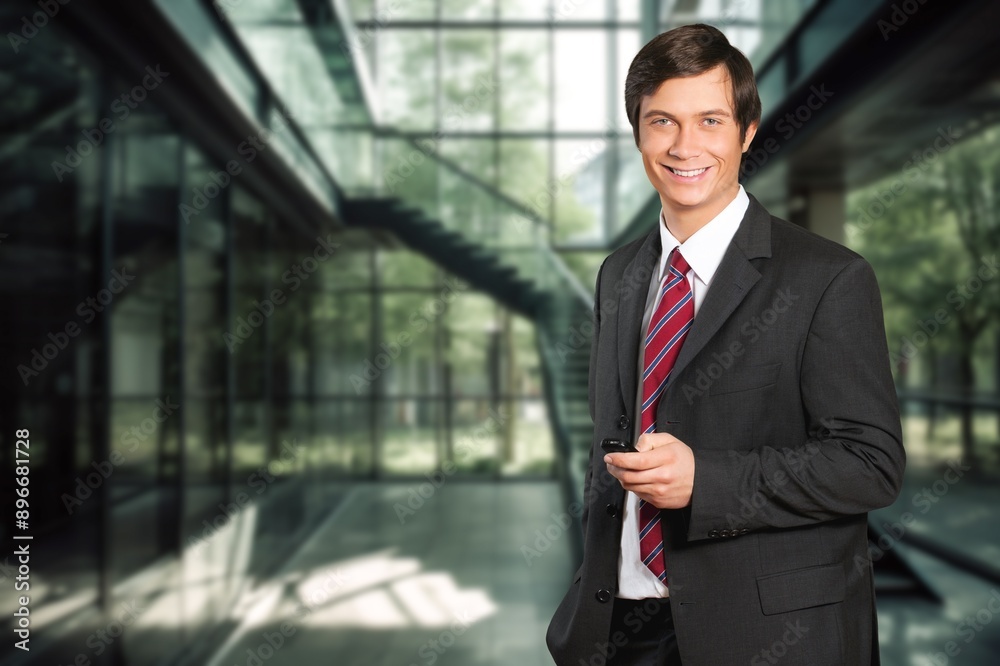 Smiling professional business man in office with mobile cellphone. Smiling professional business man in office with mobile cellphone.