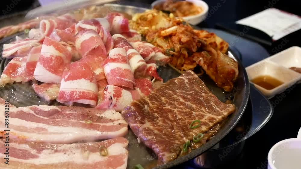 There is a motion of a worker cooking bbq meat on a table inside a Chinese restaurant with 4k resolution. There is a motion of a worker cooking bbq meat on a table inside a Chinese restaurant with 4k resolution.