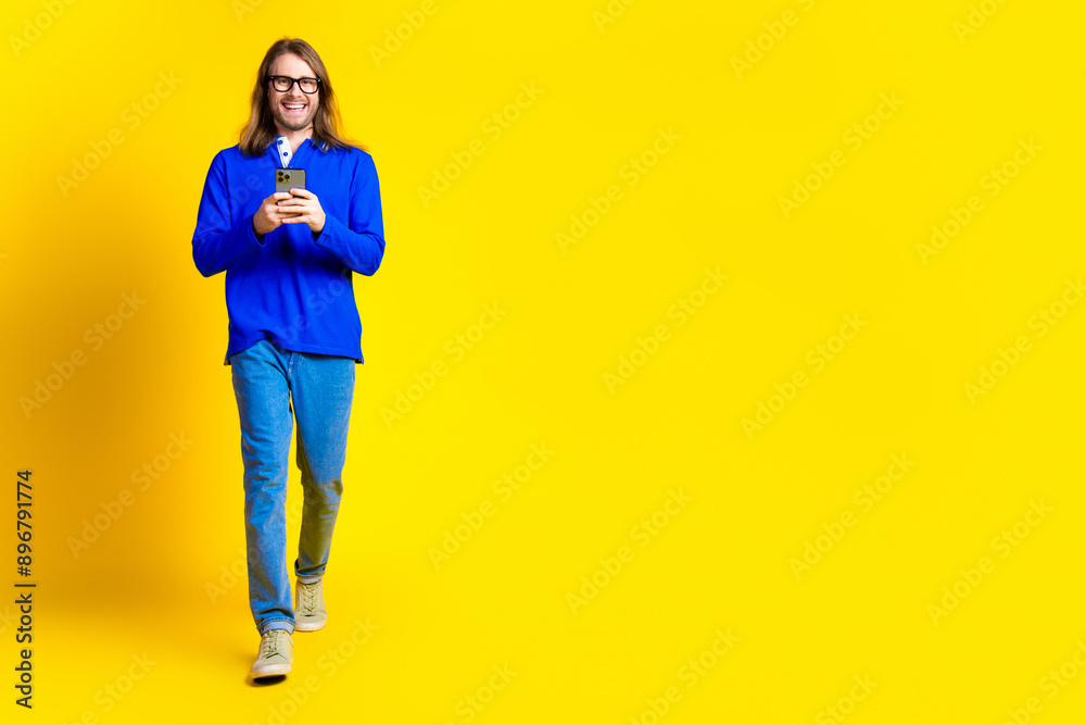 Photo of positive handsome man wear trendy blue clothes go empty space isolated on yellow color background Photo of positive handsome man wear trendy blue clothes go empty space isolated on yellow color background