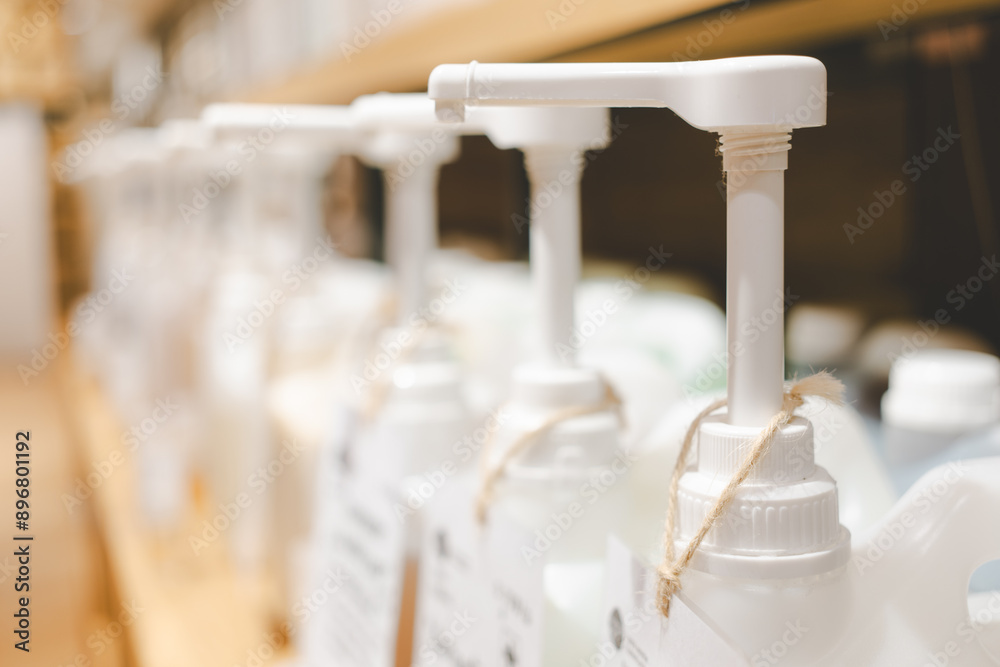 Bottles with pump dispensers in a row. Side shot of refillable cleaning product like shampoo and soap in dispenser tank for sustainable and eco friendly lifestyle. zero waste store. Bottles with pump dispensers in a row. Side shot of refillable cleaning product like shampoo and soap in dispenser tank for sustainable and eco friendly lifestyle. zero waste store.