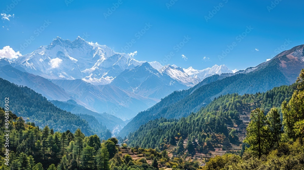 Fototapeta premium Majestic Himalayan landscape with snow-capped peaks, deep valleys, and lush green forests under a clear blue sky