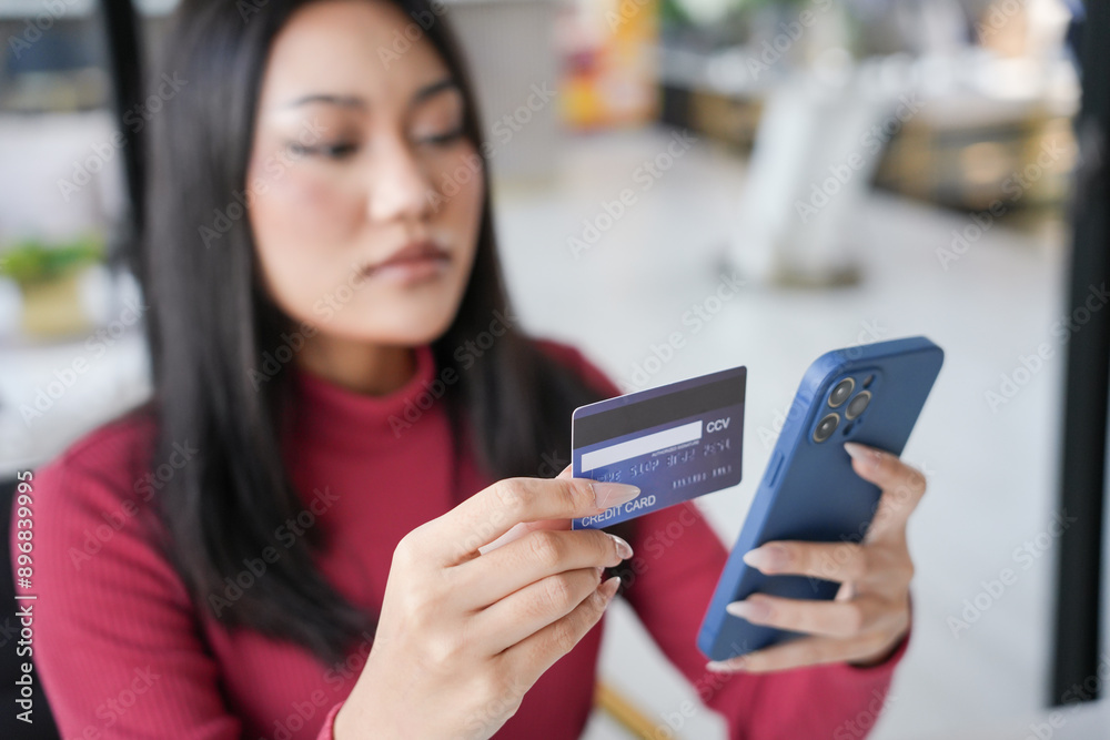 Woman shopping on laptop holding credit card for Internet online e-commerce shopping spending money Online shopping Mobile phone laptop technology concept Woman shopping on laptop holding credit card for Internet online e-commerce shopping spending money Online shopping Mobile phone laptop technology concept