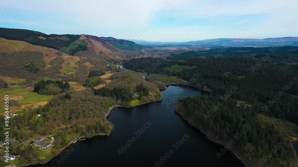 Aerial pullback above of Loch Ard, rolling hills and pine forrests in the Loch Lomond and Trossachs National Park, Scottish Highlands, Scotland on sunny spring day Aerial pullback above of Loch Ard, rolling hills and pine forrests in the Loch Lomond and Trossachs National Park, Scottish Highlands, Scotland on sunny spring day