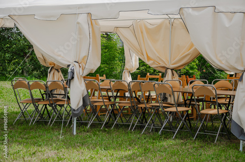 Summer tent with chairs stacked outside for celebration