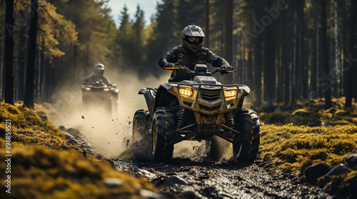 a quad moving trough the mud with two riders on it photo