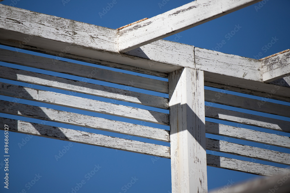 White wooden roof slats against the sky. White wooden roof slats against the sky.