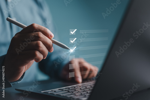 Businessman uses pen to choose or tick check marks checkboxes. Electronic survey form, checklist, fill out online form, electronic exam, and answer questions. Business performance monitoring concept.