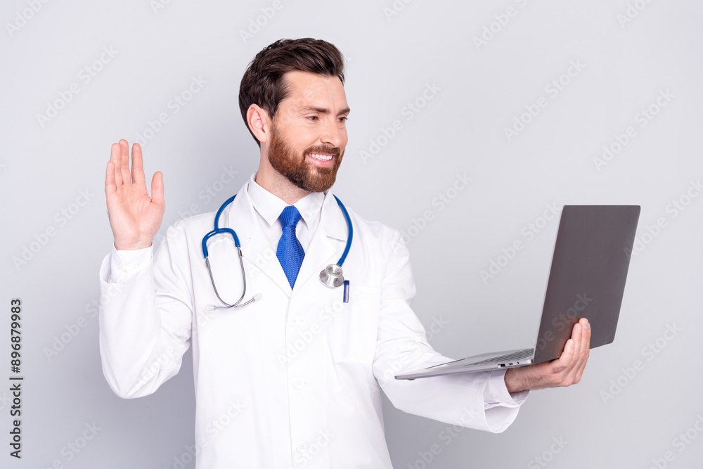 Photo of professional qualified doctor arm wave hi video call laptop wear white coat isolated on grey color background Photo of professional qualified doctor arm wave hi video call laptop wear white coat isolated on grey color background