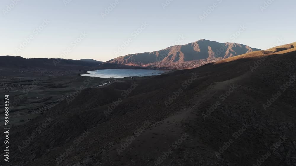 Low angle drone shot of Dique la Angostura reservoir, Tucumán, Tafí del Valle, Argentina.  Shadow dividing the landscape in two shades.
