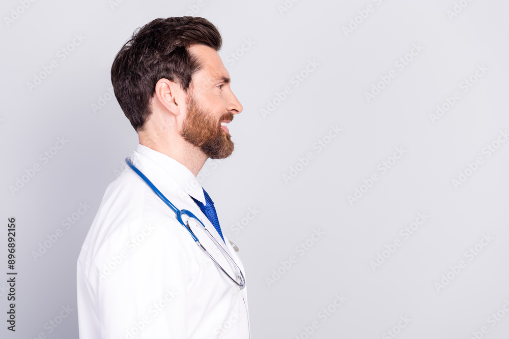 Profile portrait of experienced doctor man look empty space wear white coat isolated on grey color background Profile portrait of experienced doctor man look empty space wear white coat isolated on grey color background