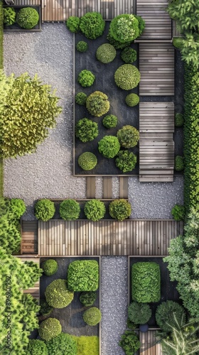 Bird seye view of a garden layout with a combination of gravel paths, wooden decking, and neatly arranged shrubs photo