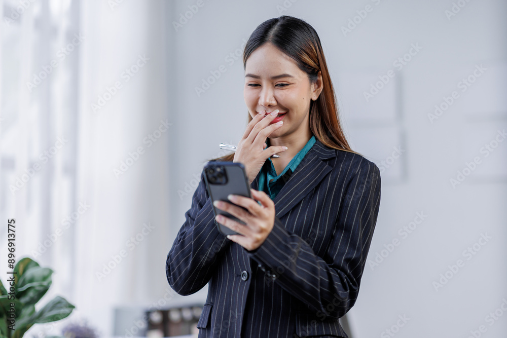 Young busy happy business asian woman employee, young female corporate executive holding digital phone standing at work. Young busy happy business asian woman employee, young female corporate executive holding digital phone standing at work.