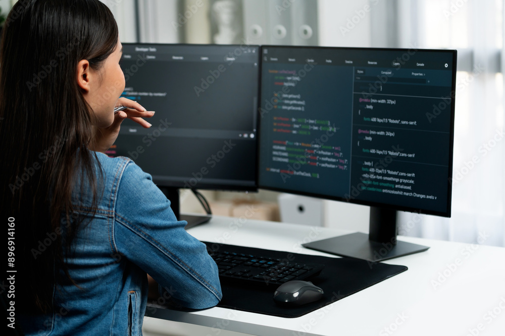 Young Asian IT developer looking online information on pc for beautiful pose with coding program data of website application, wearing jeans shirt. surround by safety analysis two screens. Stratagem. Young Asian IT developer looking online information on pc for beautiful pose with coding program data of website application, wearing jeans shirt. surround by safety analysis two screens. Stratagem.